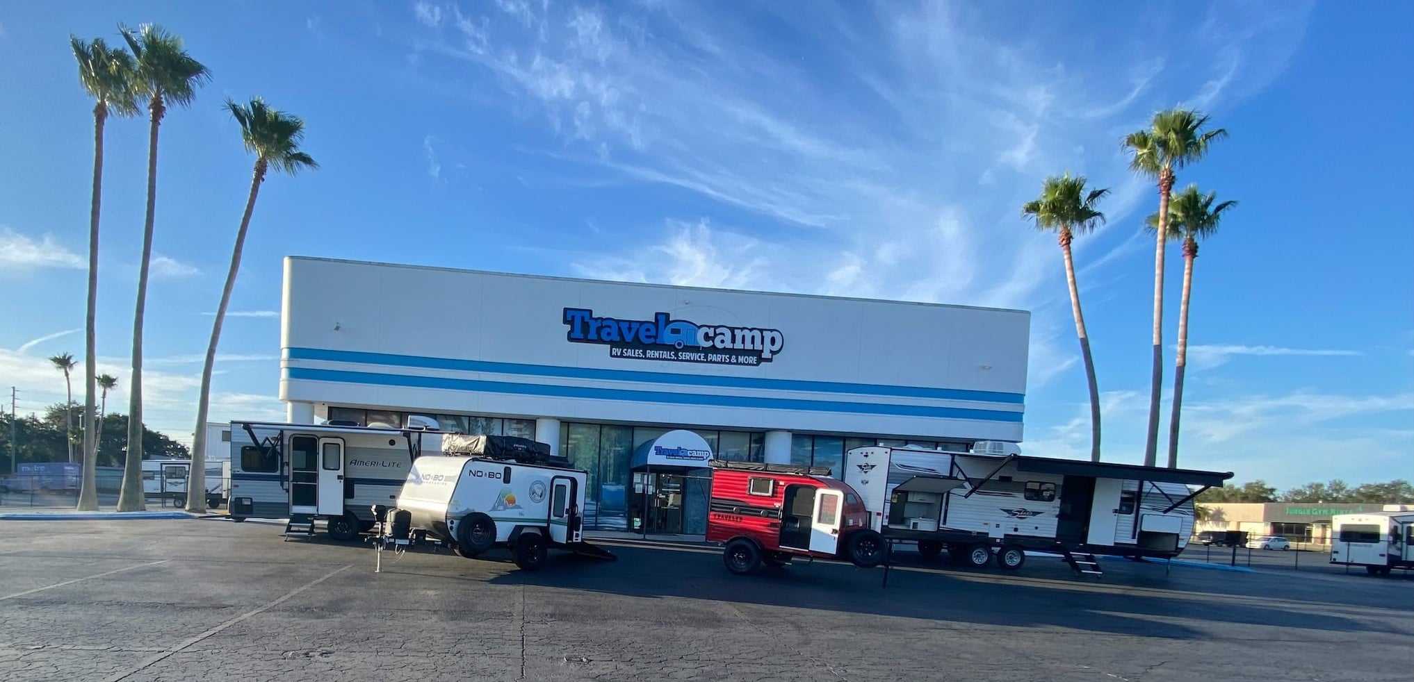 A group of Travelcamp RVs parked in front of a store in the Southeast.