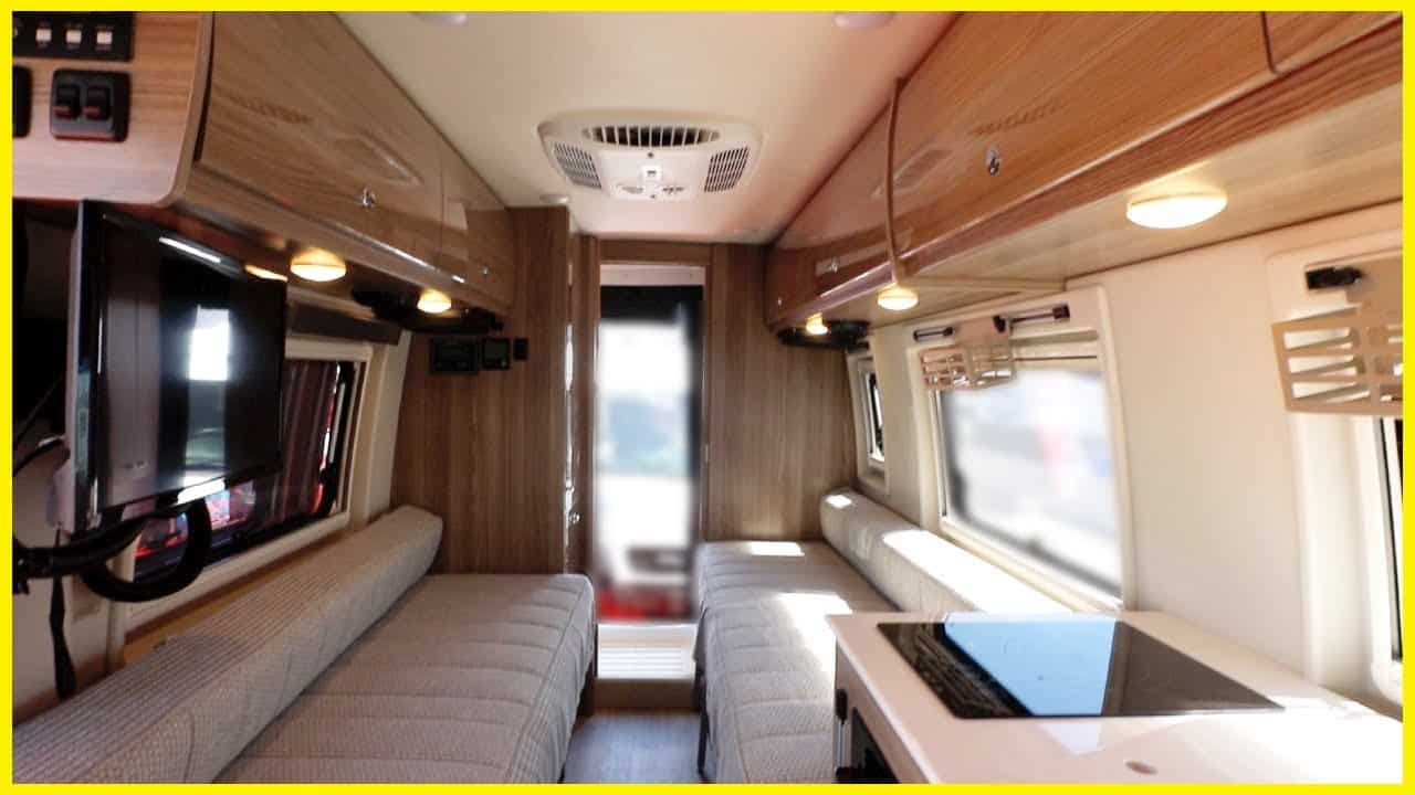 The interior of a Boldt Q70KL Sprinter Van with a couch and TV.