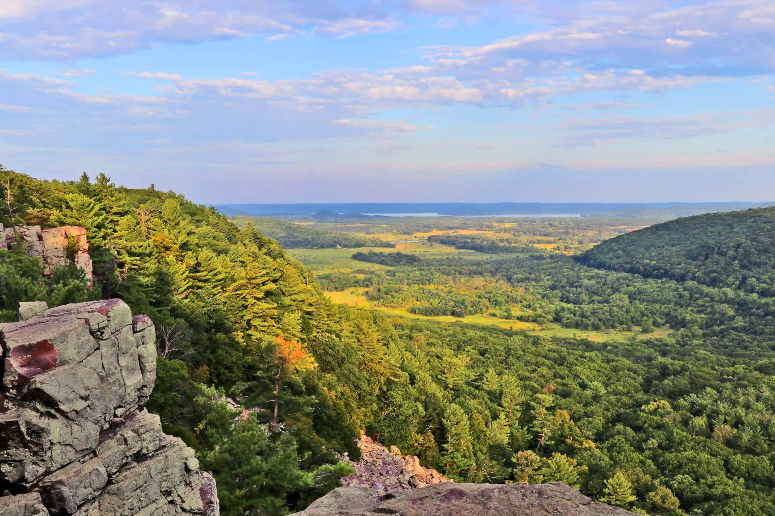 A breathtaking view from the top of a cliff in Pepin County, showcasing the picturesque valley and offering an immersive outdoors experience.