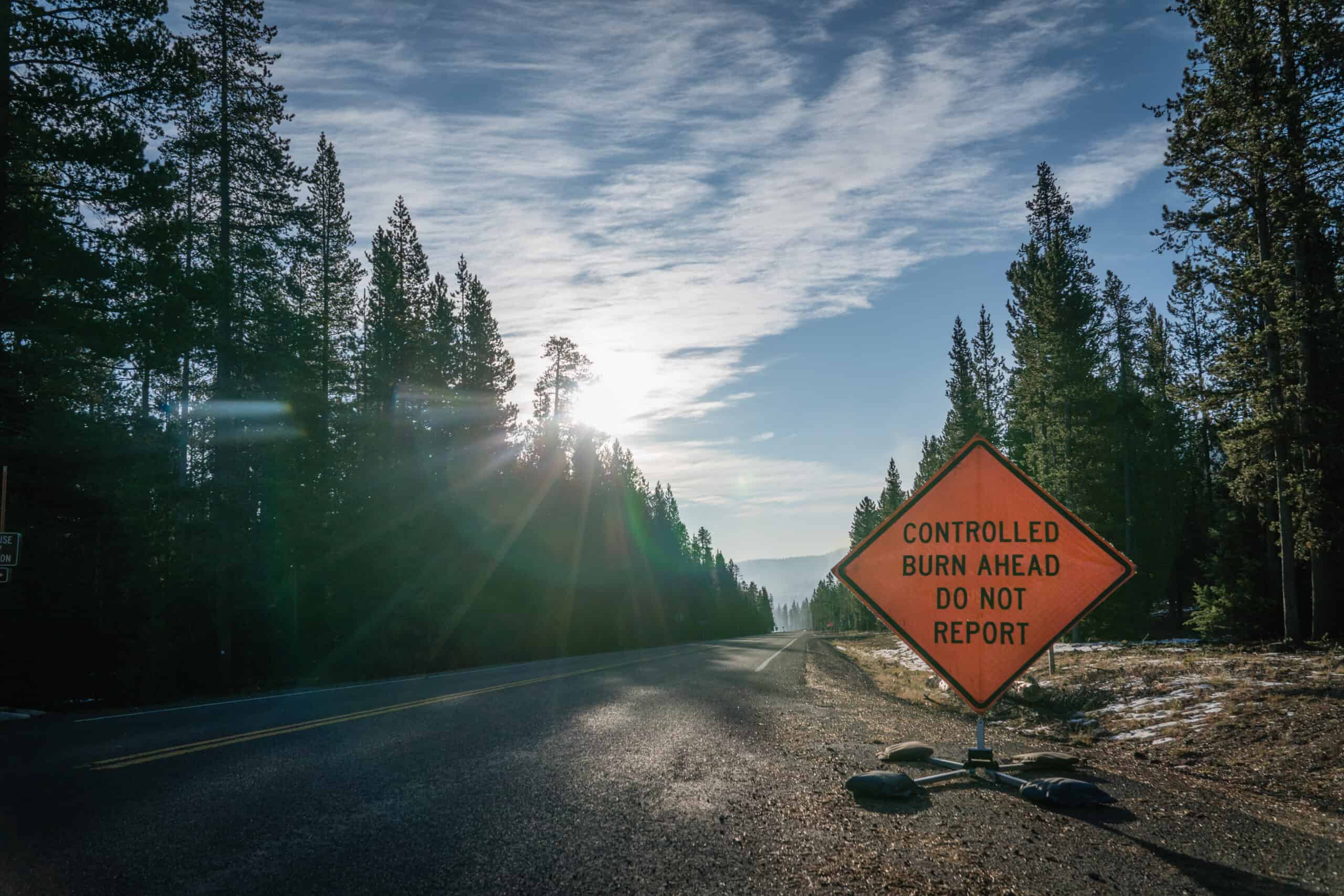 A warning sign regarding controlled burning sits on the side of a road in San Luis Obispo County.