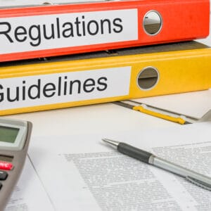 Morgan County Commission regulations and guidelines on a desk with a calculator.