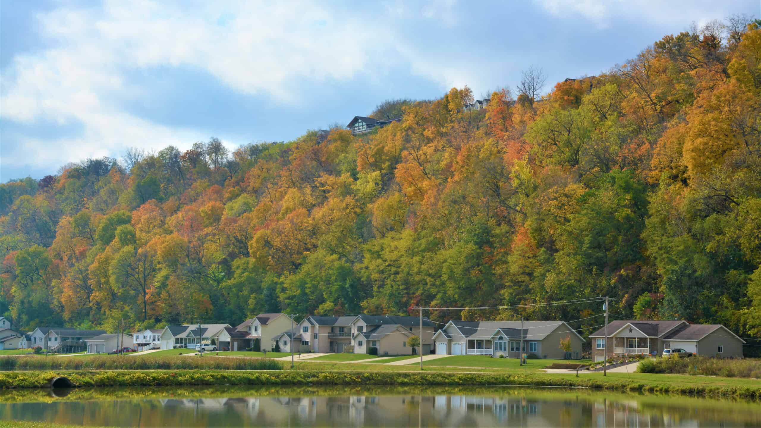 A group of houses on a hillside near a body of water in close proximity to Pikes Peak.