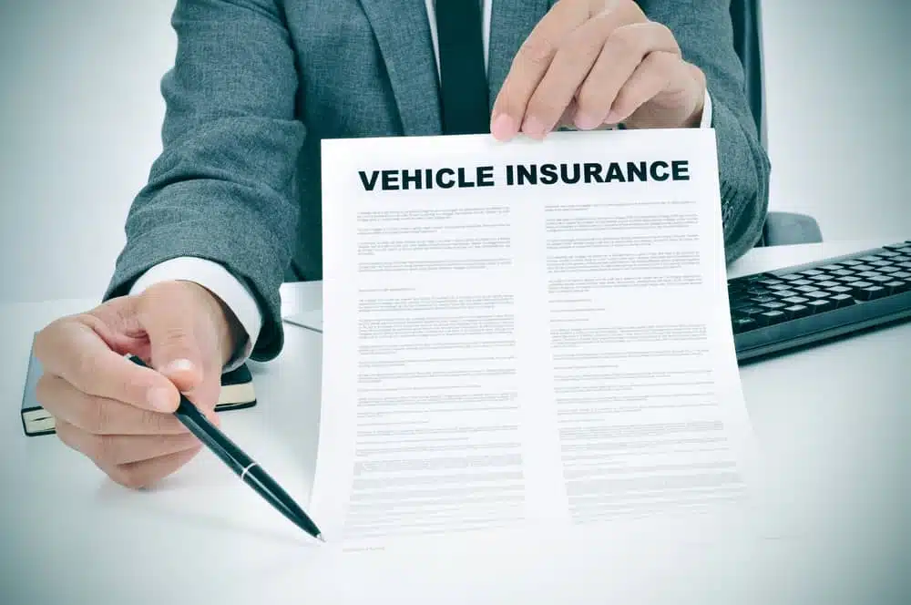 A businessman signing an RV Rental Insurance document.