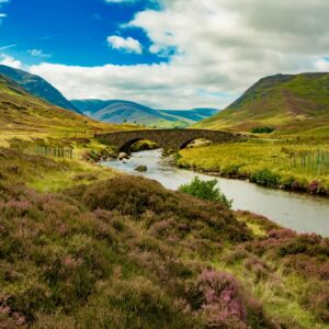 A glamping site featuring a bridge over a river in the Scottish Highlands, nestled within Cairngorms National Park.