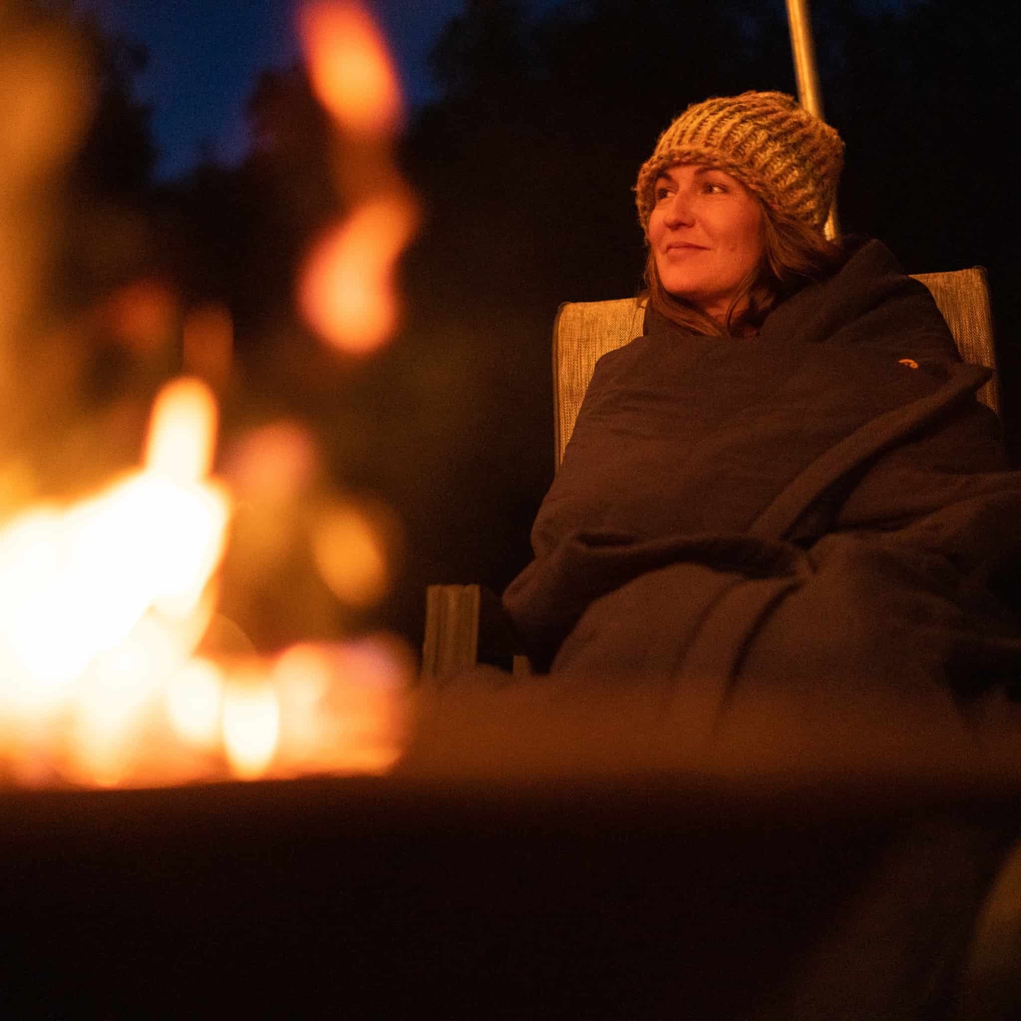 Keywords: Cold Weather Sensitivities

Description: A woman sitting in a chair next to a fire, seeking relief from her cold weather sensitivities.