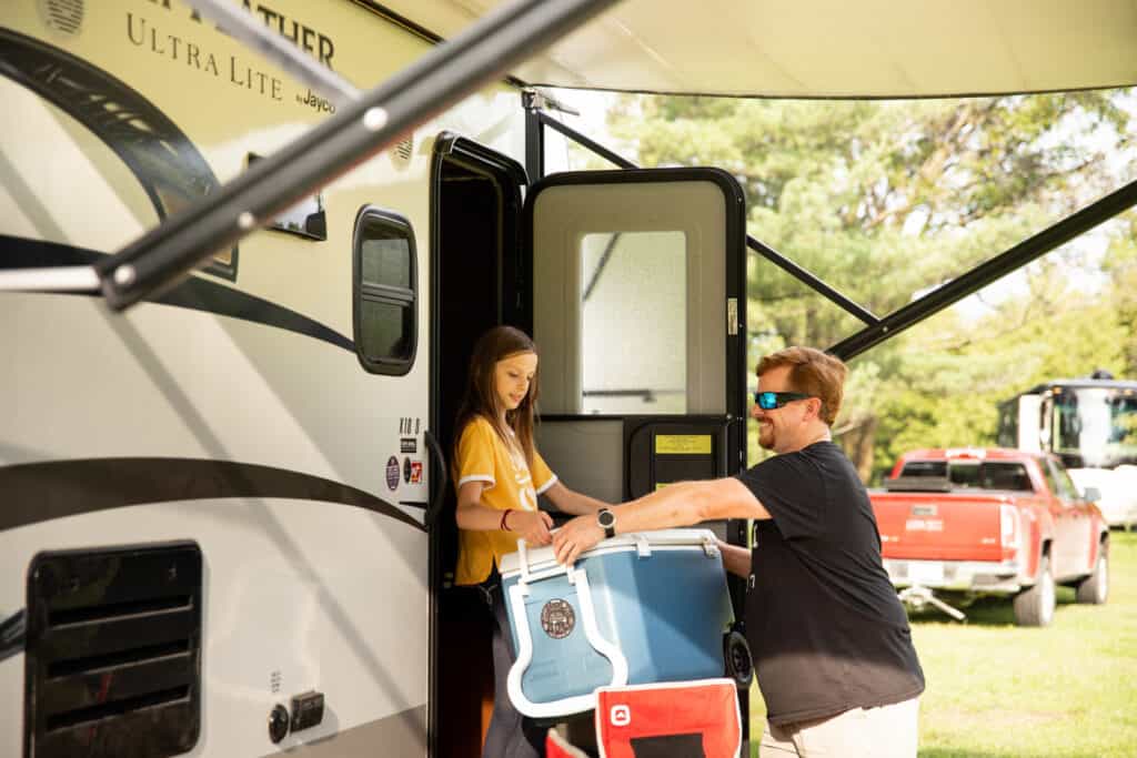 A couple loading a cooler into an RV during a nearcation.