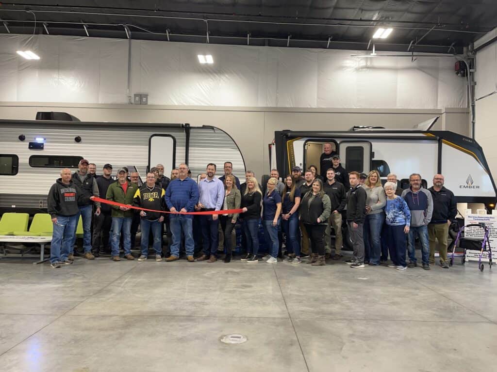 A group of people standing in front of an RV during the first annual openhouse organized by Premier RV LLC.