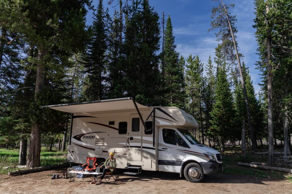 An RVshare Booking parked in a forest near trees, allowing Park Owners to earn revenue.