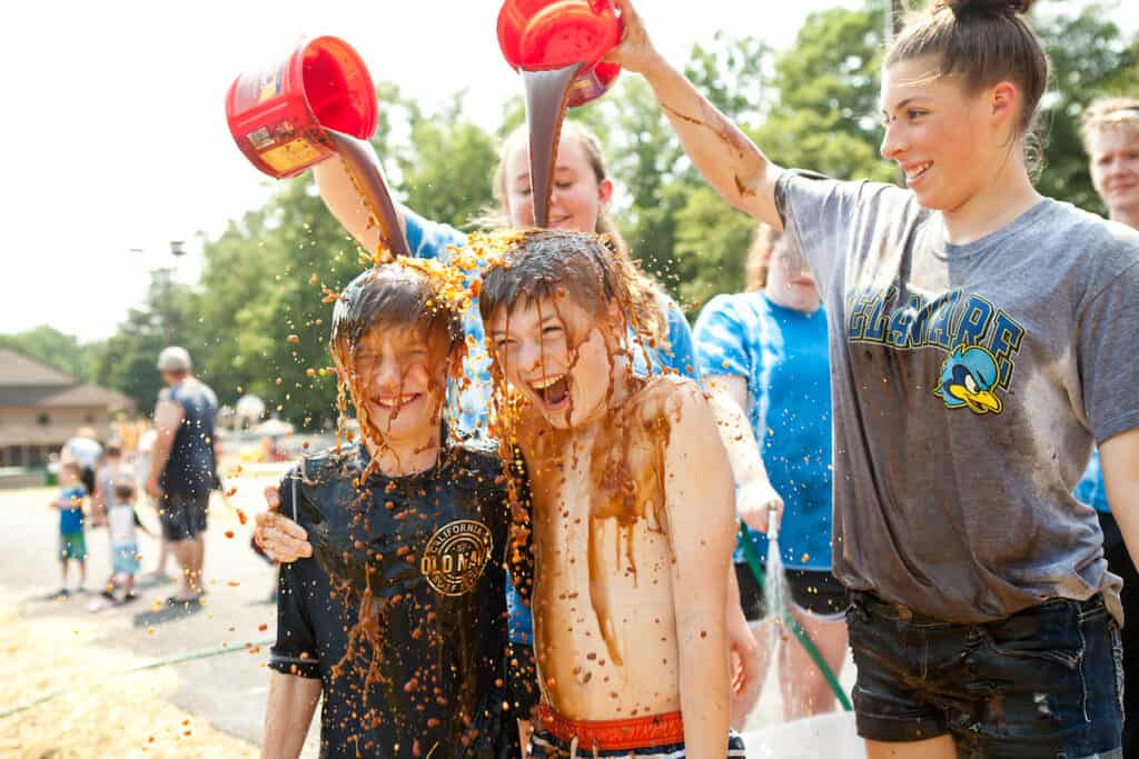 A group of children enjoying World Chocolate Day activities and playing in the mud at Jellystone Park locations.