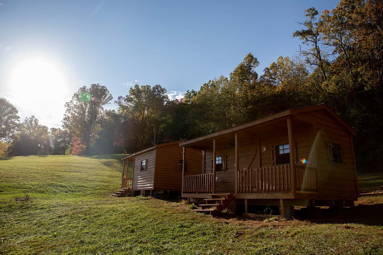 A small cabin at Floyd Family Campground nestled in the middle of a grassy field.