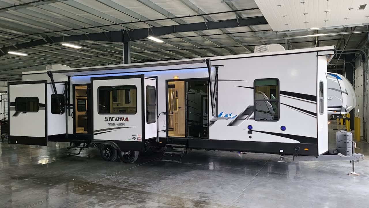 A black and white RV, the 2022 Sierra 403RD, is parked in a warehouse.