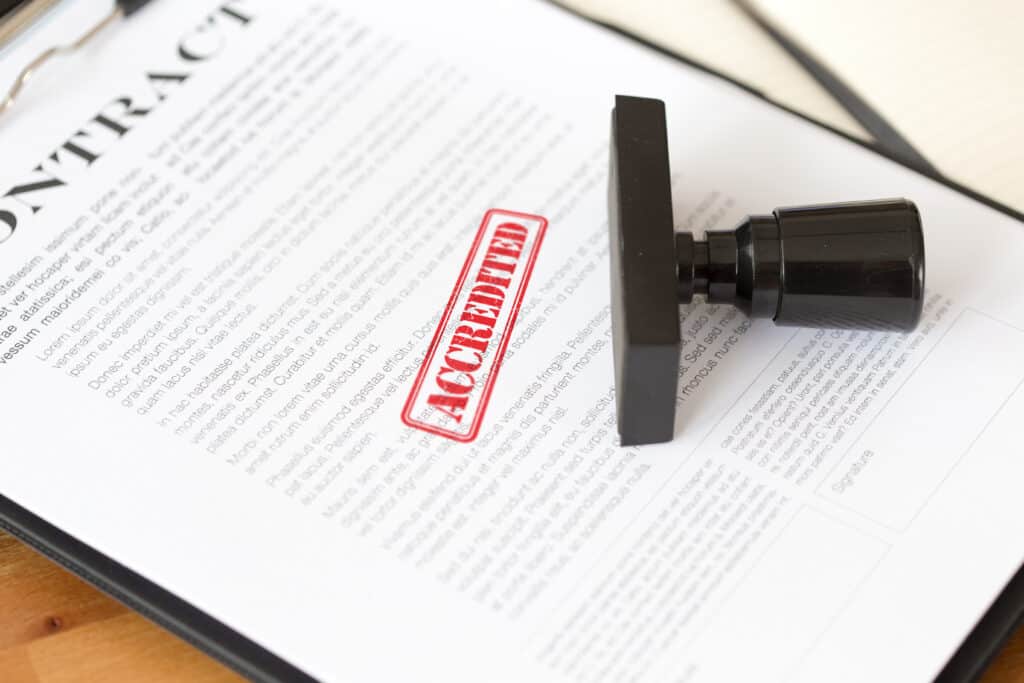 A contract with an ANSI Standards Accreditation rubber stamp on top of it.