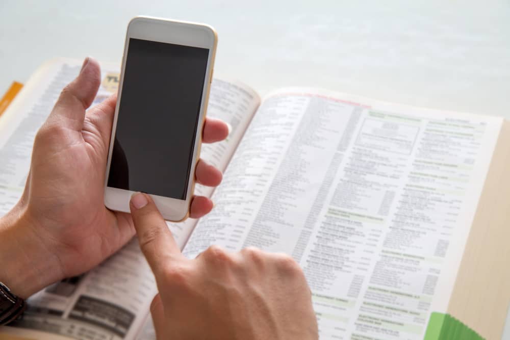 A hand holding a smart phone displaying the 2022 Vendor Guide.