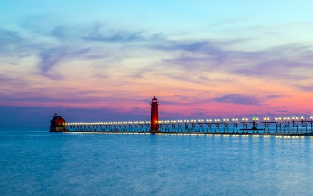 Gearing Up for a Busy Memorial Day Weekend at Michigan State Parks amidst the serene scenery of a lighthouse in the middle of the water at sunset.