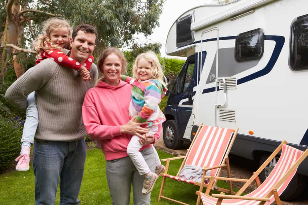 Albertan family posing in front of an RV at a campground during Victoria Day weekend.