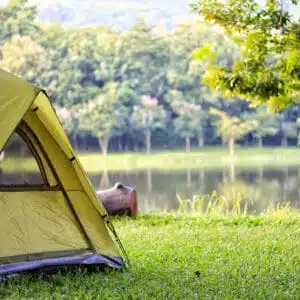 A campsite is set up on the grass near a lake during the May Long Weekend at an Alberta Parks location.