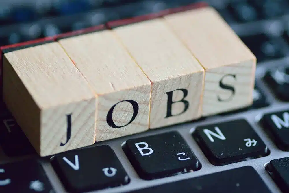 A wooden block with the word Job Board on top of a keyboard.