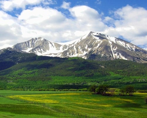 A picturesque mountain range with snow capped mountains in the background, perfect for Memorial Day camping in the Aspen-Area.