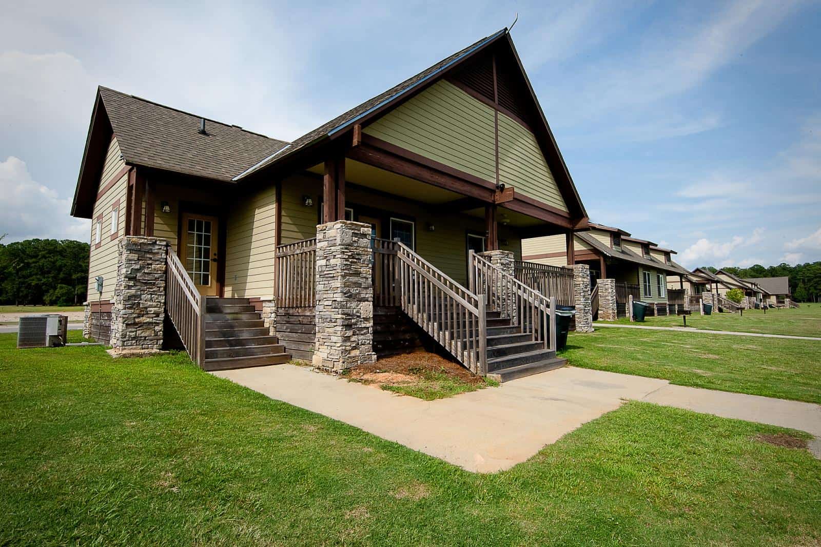 A house with motorized outdoor recreational amenities leading up to a grassy yard near Lakepoint State Park.