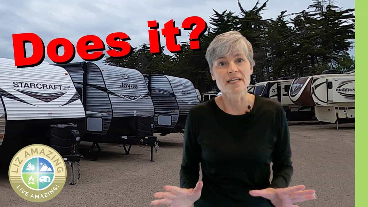 A woman standing in front of a group of RVs, contemplating the buying tips.