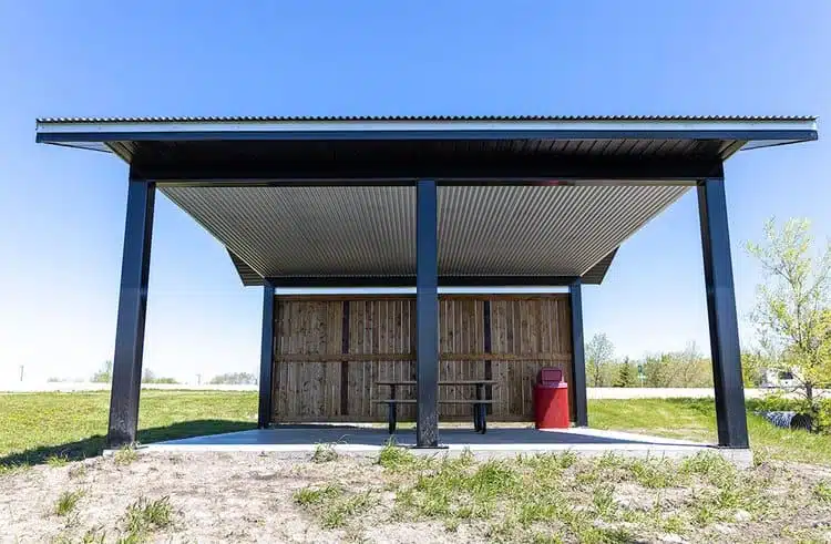 A wooden picnic shelter in the middle of a grassy field near Lake Minnewasta.