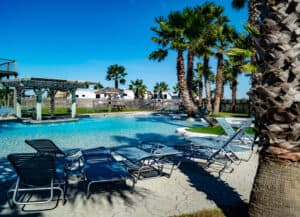 A pool with lounge chairs and palm trees, perfect for Ohio State Parks visitors looking to beat the extreme heat without worrying about pool fees.