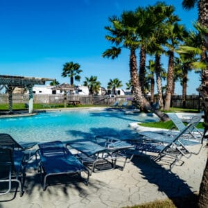 A pool with lounge chairs and palm trees, perfect for Ohio State Parks visitors looking to beat the extreme heat without worrying about pool fees.