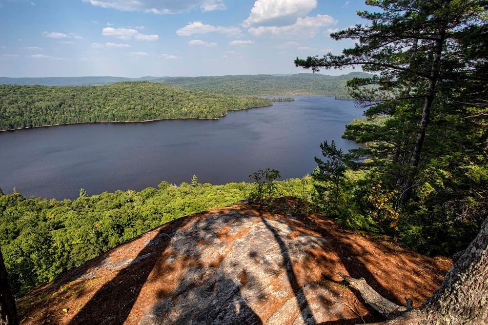 A breathtaking view of a lake nestled in the Northern Communities, surrounded by the majestic beauty of Mississagi Provincial Park.