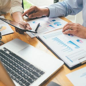 The Rapido Group, in collaboration with FCA Bank, engaging in a Pan-European Partnership, involving business people analyzing graphs on a table.