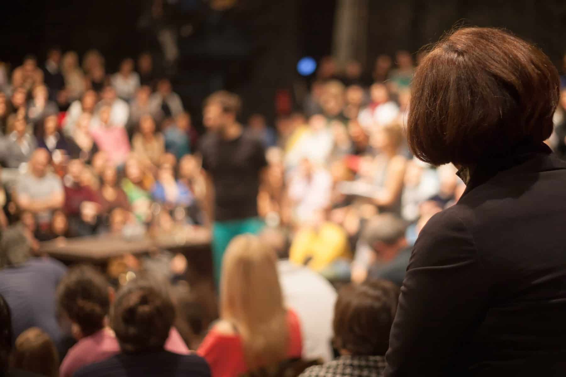 A woman is standing in front of an audience at a Public Inquiry in Wickford.