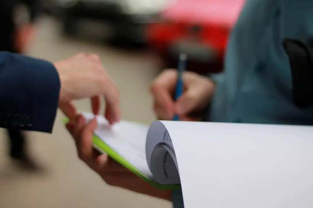 A businessman handing over a petition to another person.