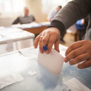 A person is putting a vote into a voting box during an election for the board of directors of RVIA.