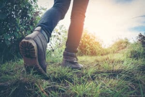 A person walking on a trail in a pair of hiking boots, braving severe rainfall.