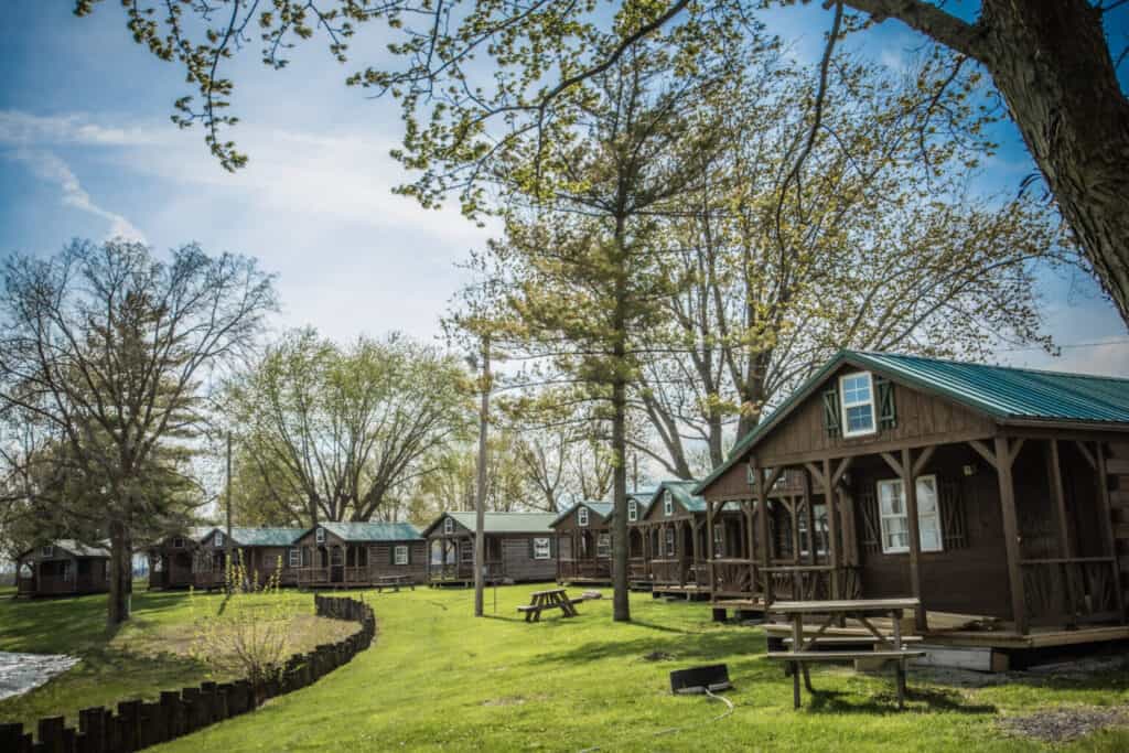 Pine Lakes, a Camping Resort featuring a row of cabins with stunning lake views.