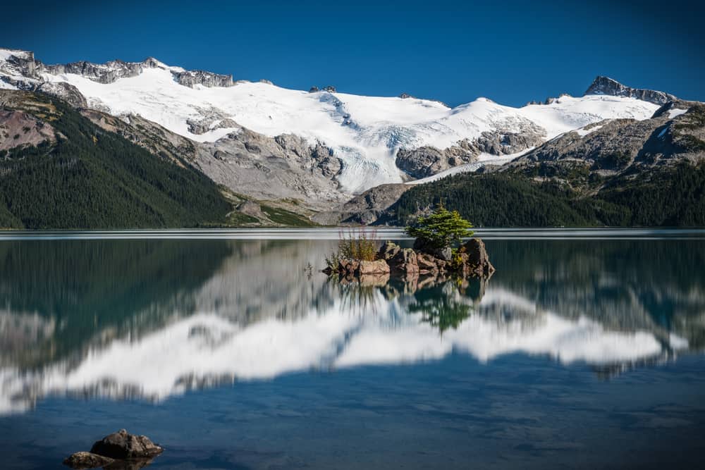 Garibaldi Provincial Park features a stunning lake with the majestic beauty of a reflected mountain, offering campgrounds for visitors to fully immerse themselves in nature's wonders.