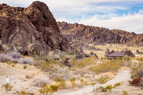 A dirt road in the desert near Barstow Campground with rocks in the background.