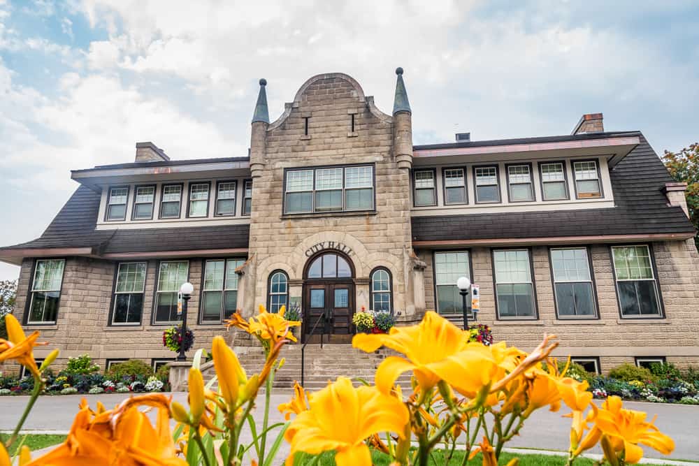 A large stone building with yellow flowers in front of it, located in the City of Fernie.