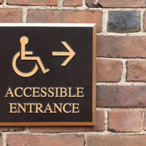 An accessible entrance sign on a brick wall, indicating the level of accessibility for BCLCA member campgrounds.