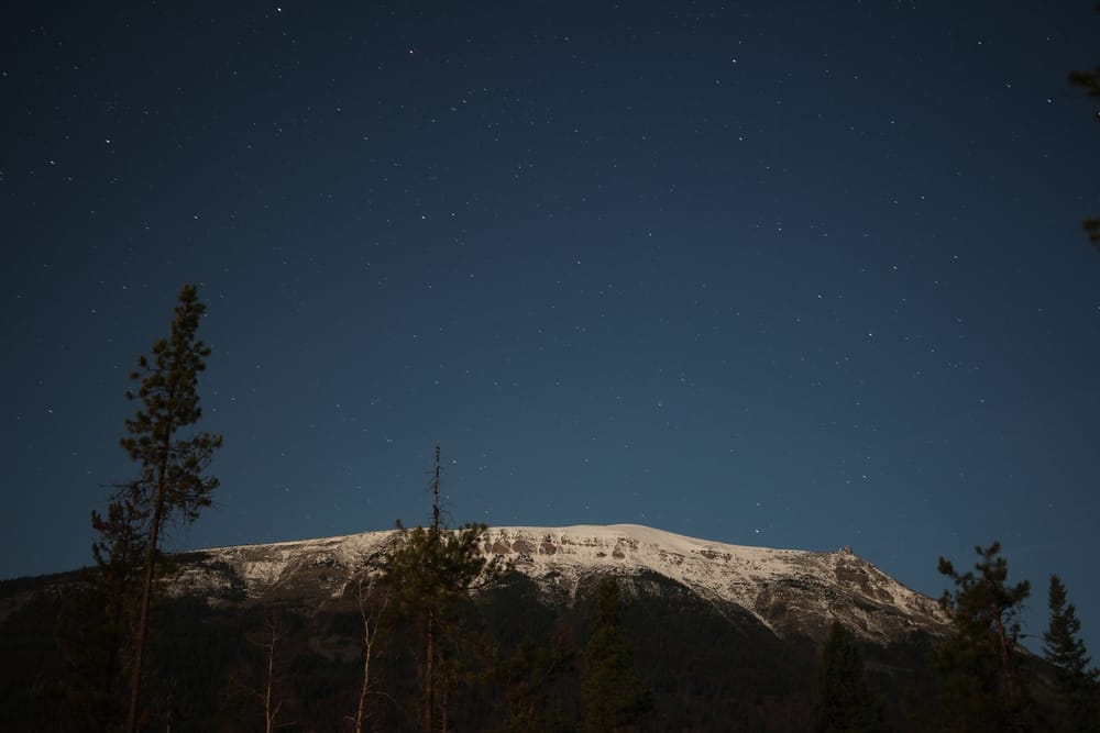 A Chetamon mountain covered in snow under a starry sky.