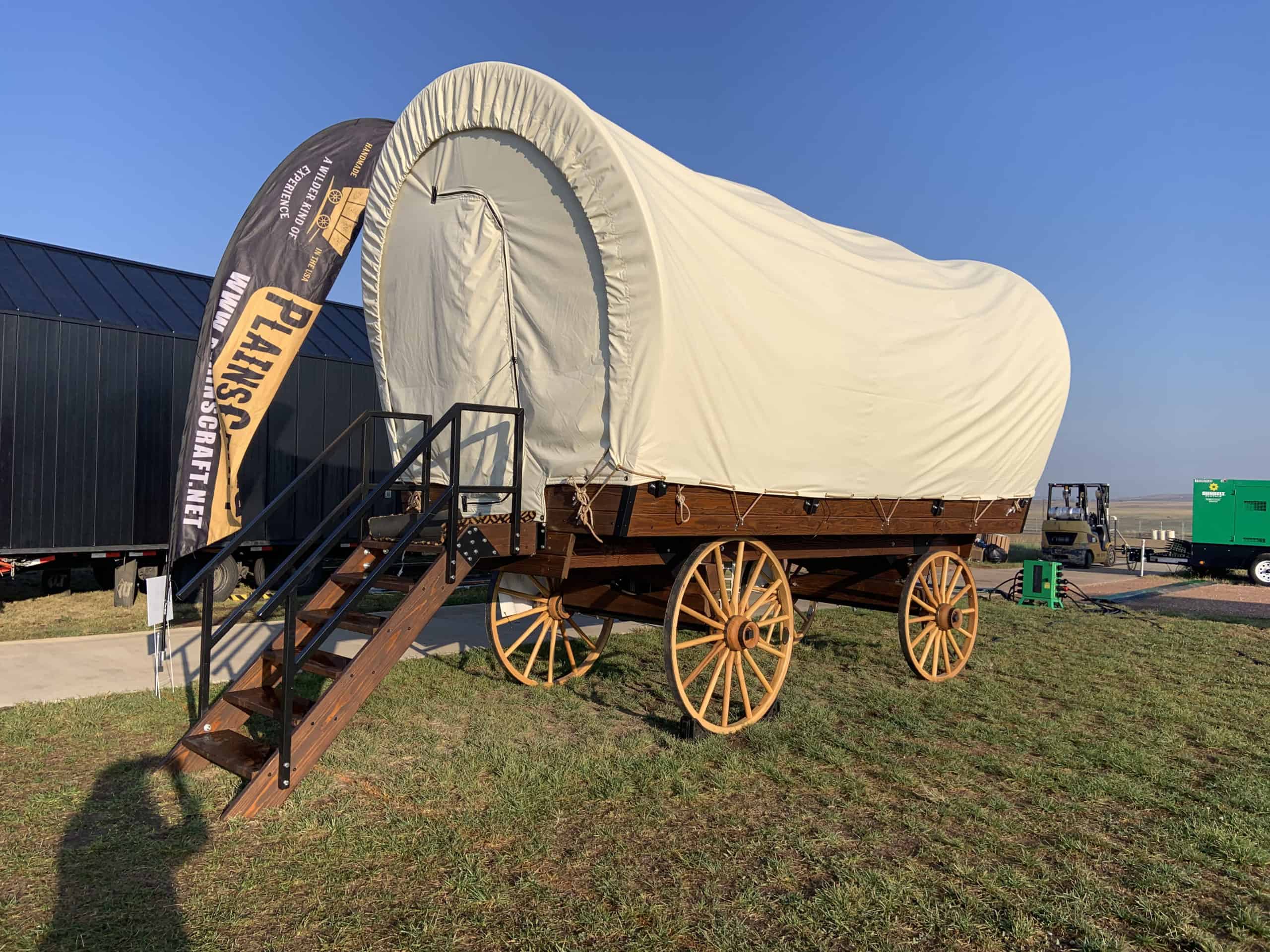 A Small Wagon sits on a grassy field.