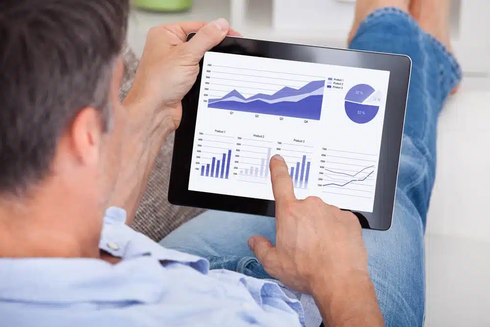 A man holding a tablet with Mercedes-Benz Vans' global sales graphs, recording a 4% increase.