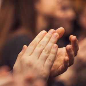 A group of people clapping their hands at the KOA Convention.