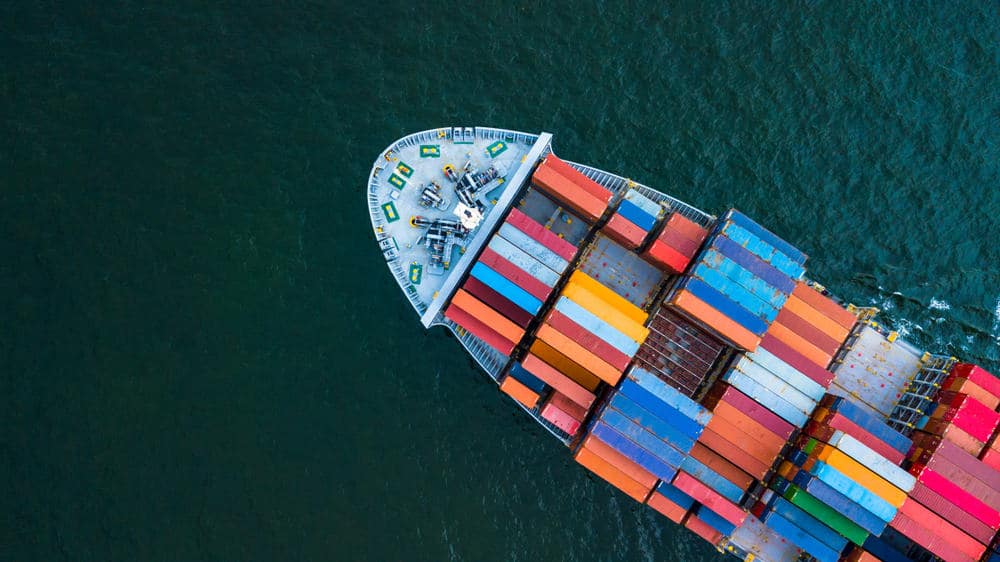 A forecasted aerial view of a container ship in the ocean.