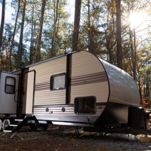 A Lippert RV with a Keyless RV Door Lock parked in the woods.