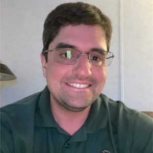 A man wearing glasses and a green shirt delivers a captivating MC Fireside Chat on January 18, 2023.