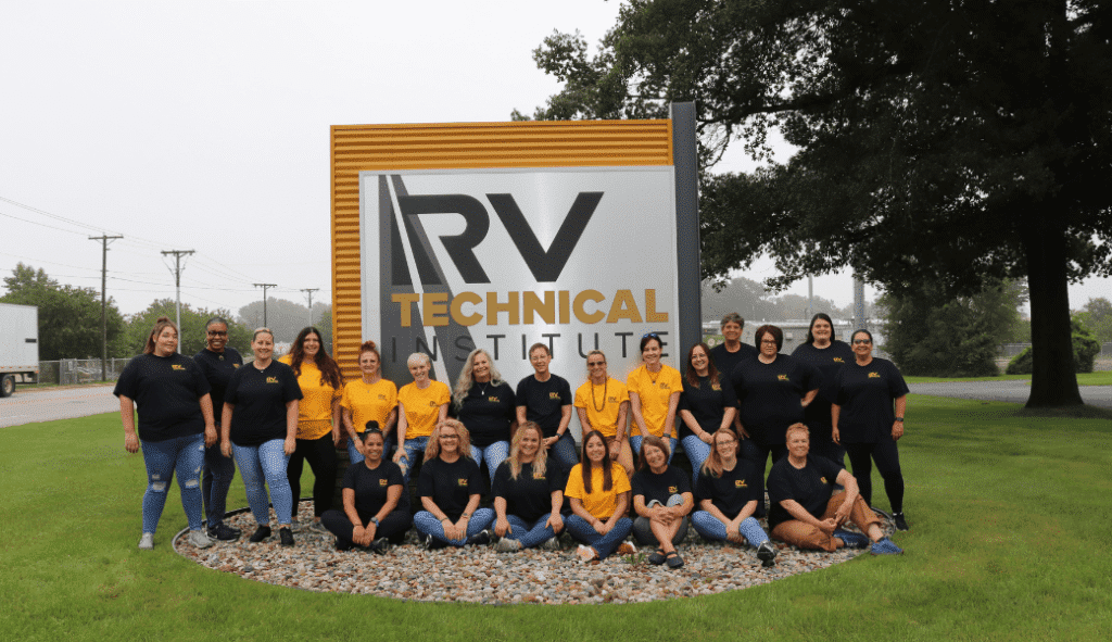 A group of people posing in front of a sign that says RVTI.