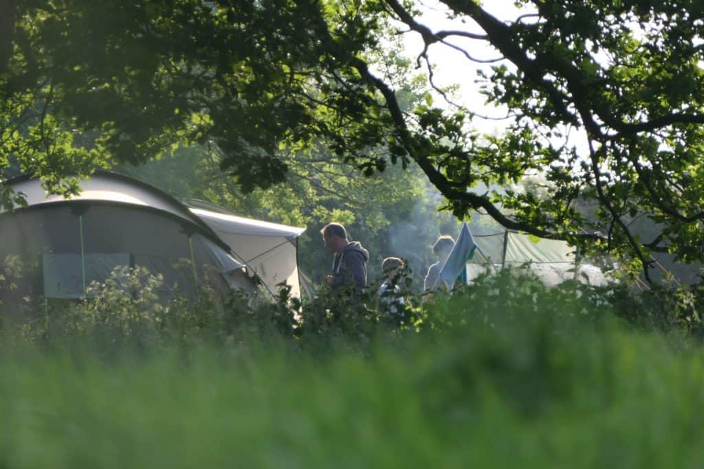 A group of people standing next to an eco-friendly tent in Suffolk's Alde Valley.