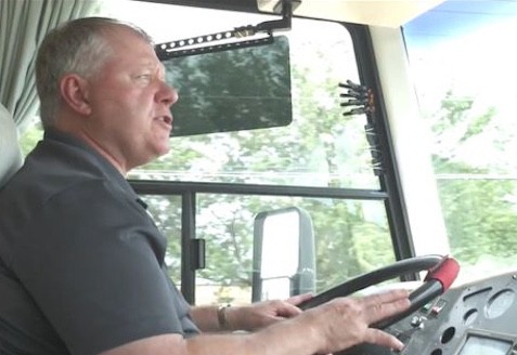 Dave Solberg sitting in the driver's seat of a bus, traveling with pets and hosting seminars.