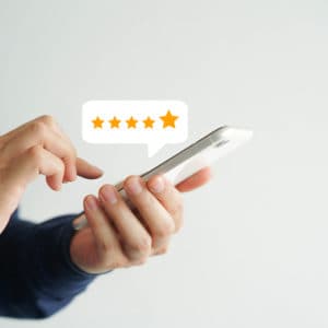 A man holding a smartphone with a luxury star rating on it.