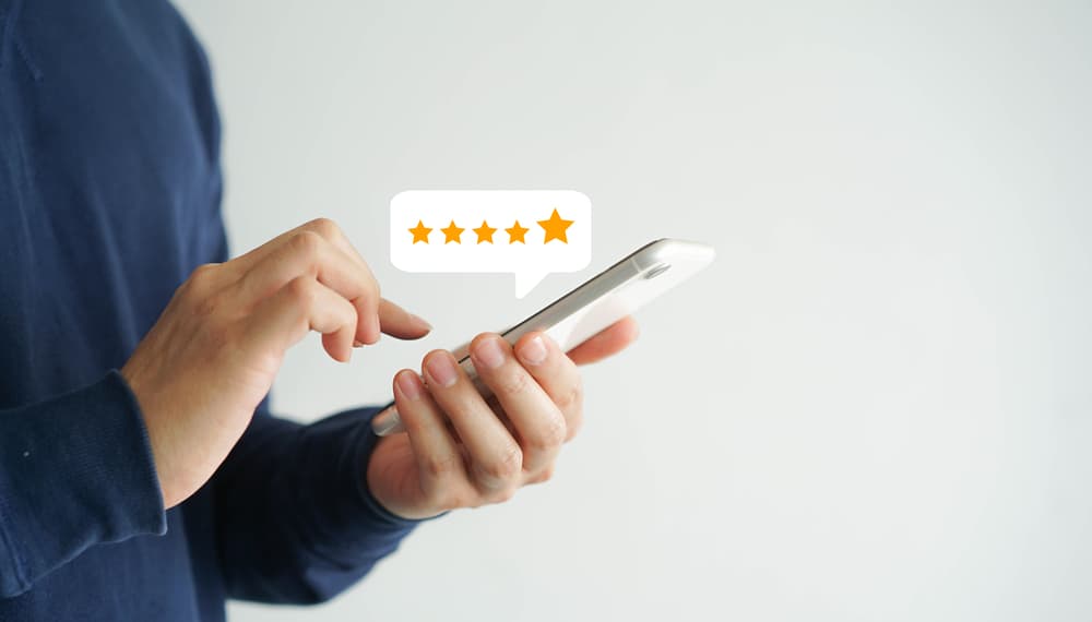 A man holding a smartphone with a luxury star rating on it.